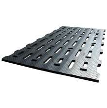 Svart gummimatta med slitsar och halkskyddad yta, avsedd fr liggbs eller stallgngar i lantbruksmilj.