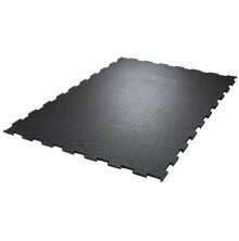 Svart, rektangulr gummimatta med pusselkanter och halkskyddsmnster, avsedd fr golv i stall eller industri